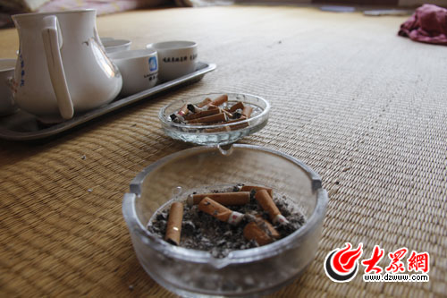 凌亂的煙頭和未喝完的茶水