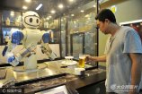 2017年8月6日,山東青島金沙灘啤酒城,顧客拿起機(jī)器人倒入啤酒的啤酒杯。